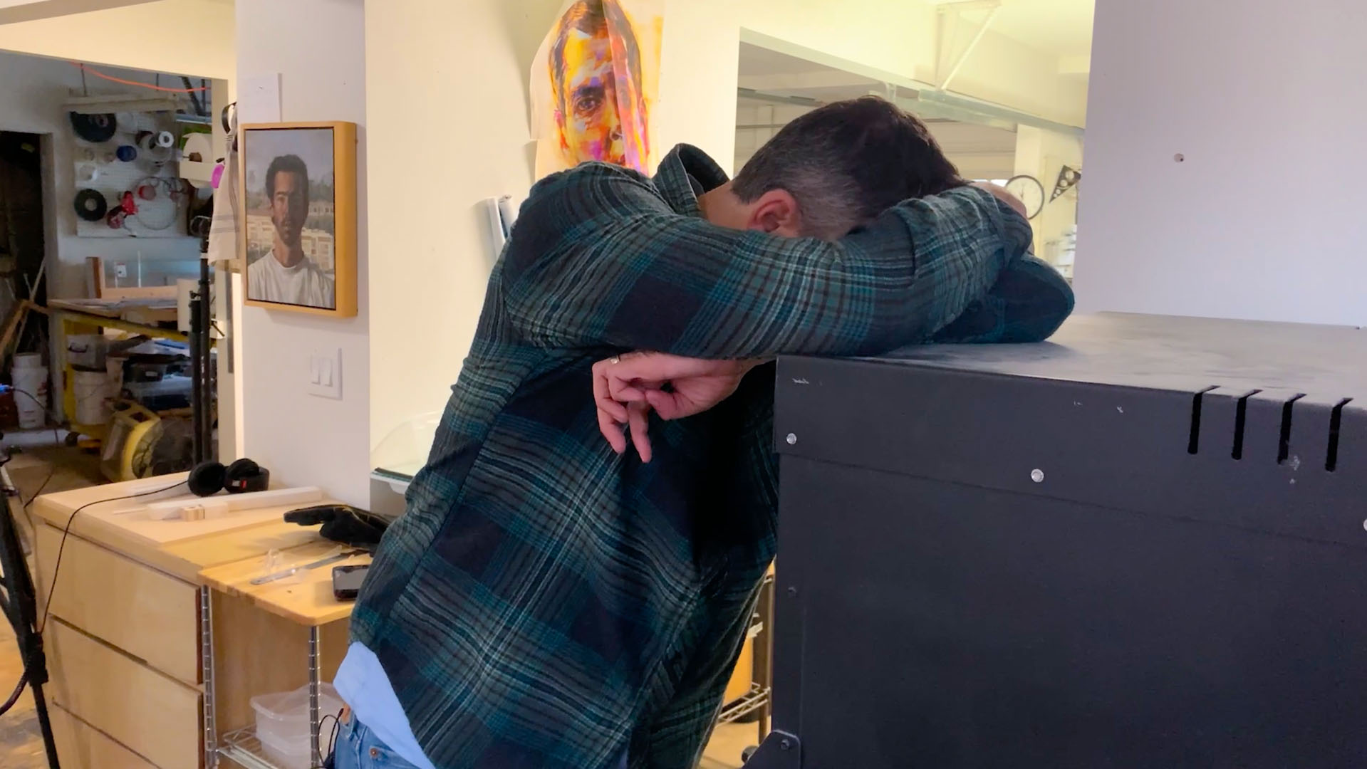 Tim Carey leaning against a kiln, exhausted after a long day of problem-solving